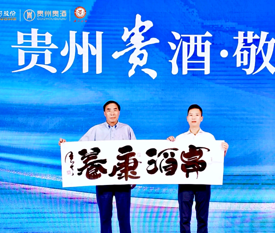 海南省江苏商会首席特别顾问、海南省新闻界书画家协会主席李笑天(中),向贵酒品牌赠送墨宝