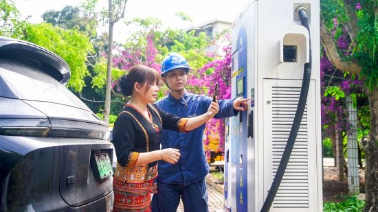 　　海南电网公司白沙供电局工作人员在白沙黎族自治县鹦哥岭景区帮助客户使用“海南充电桩”APP为新能源汽车充电。余盛本 &nbsp;摄