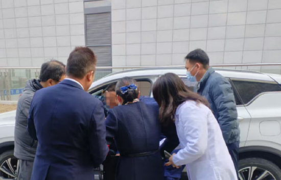 圖為現(xiàn)場工作人員從車里轉運患者