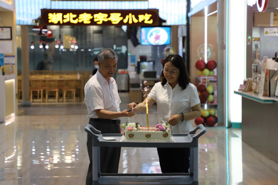 湖北省粮食局产业与市场处处长龚伟与黄鹤楼公园管理处副主任熊菁为“黄鹤楼鹤”鹤仙茗店开业一周年庆祝