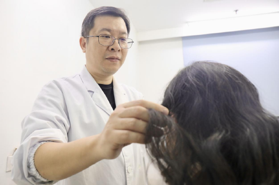 （武汉市第一医院皮肤科毛发专病成员、郑亮医生坐诊脱发专病门诊  通讯员代雨朦 摄）