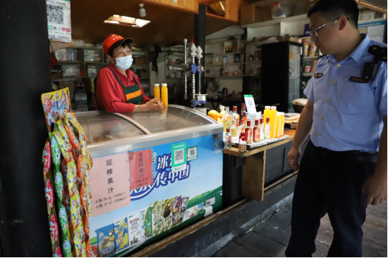 杨振东（右）介绍现榨橙汁明码标价情况