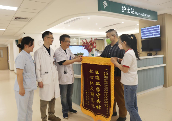 张先生及夫人送上锦旗向医护致谢 通讯员代雨朦 摄