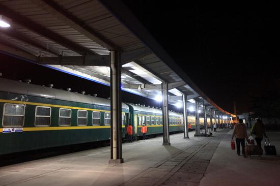 两名旅客在松滋火车站站台上并排前行,准备上车.他们的目的地是广州.