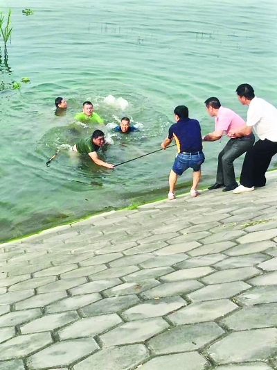 武汉一男子钓鱼滑落水中 众市民汉江边结人梯救人