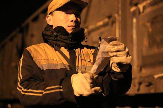 制动员雷志勇正在核对计划确认待解编车辆的开口车号.  陈龙摄