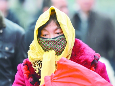 昨日武昌火车站西广场上,工作人员和旅客裹得严严实实.