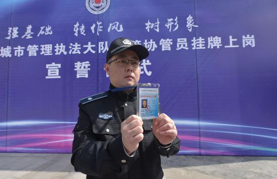 江岸百余名城管协管员领取工作牌 今后将亮牌上岗