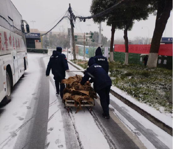 图为物业人员运输防滑麻袋、铺设在院内主干道