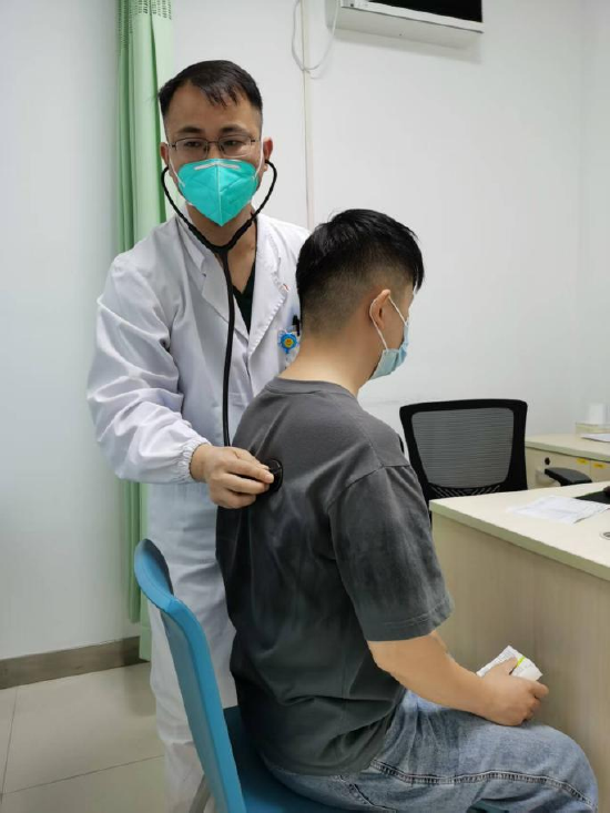 杨澄清正在为一名年轻的患者听诊