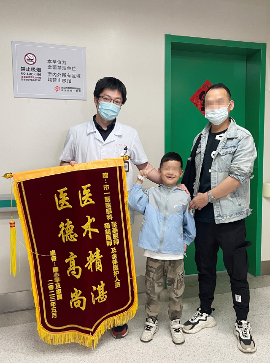 出院时,俊俊爸爸送锦旗致谢武汉市第一医院眼科医护