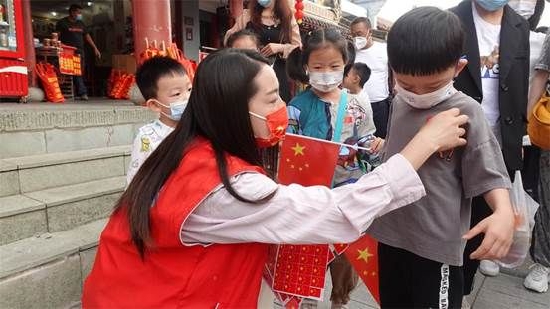 志愿者为游客国旗贴纸