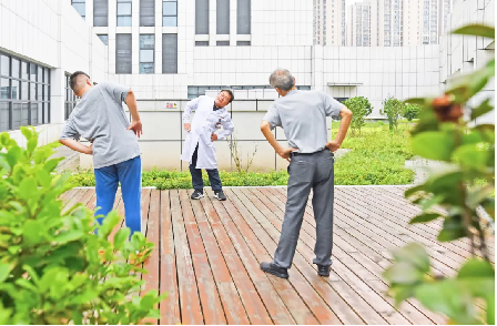 康复医学科主任医师张伟带领患者在花园阳台做康复操