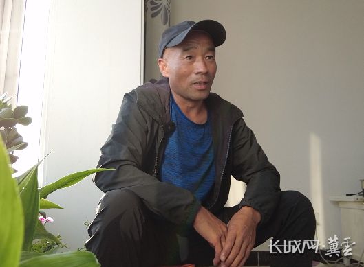马文财坐在新房的客厅里。长城网·冀云客户端记者 冯硕 摄