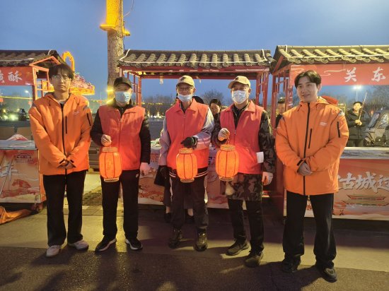 （图片说明：现场环卫工人共同制作非遗灯笼）