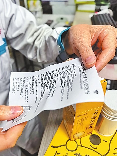 10月14日，在郑州市金水区一家药店，店员正在展示某药品的说明书。