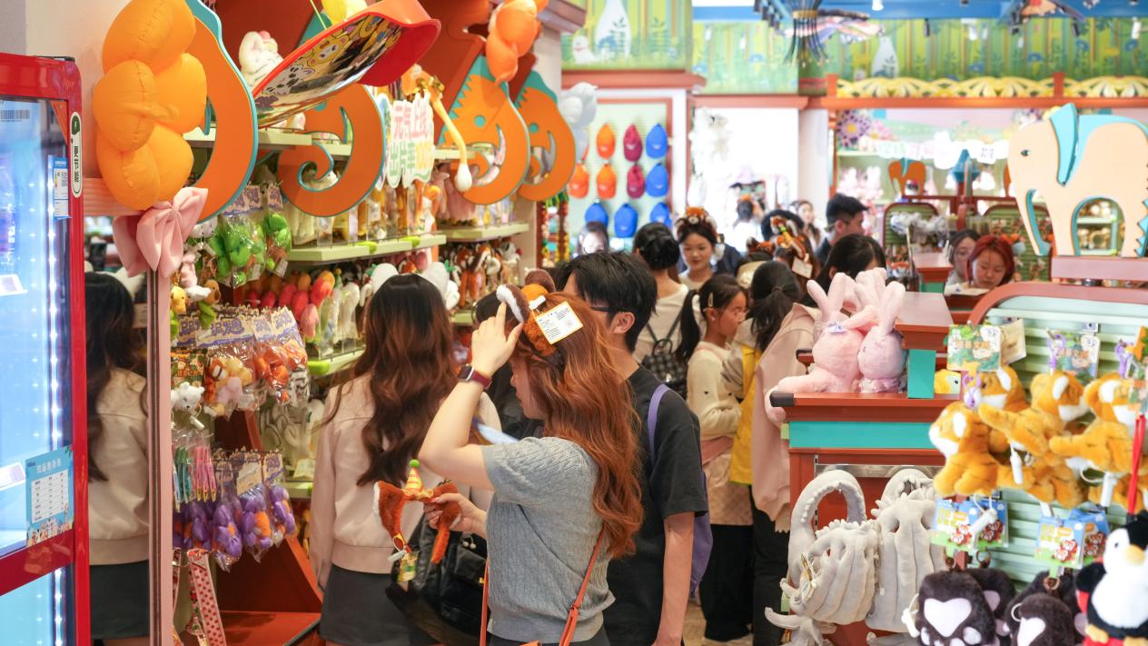 （游客在动物王国选购文创产品）