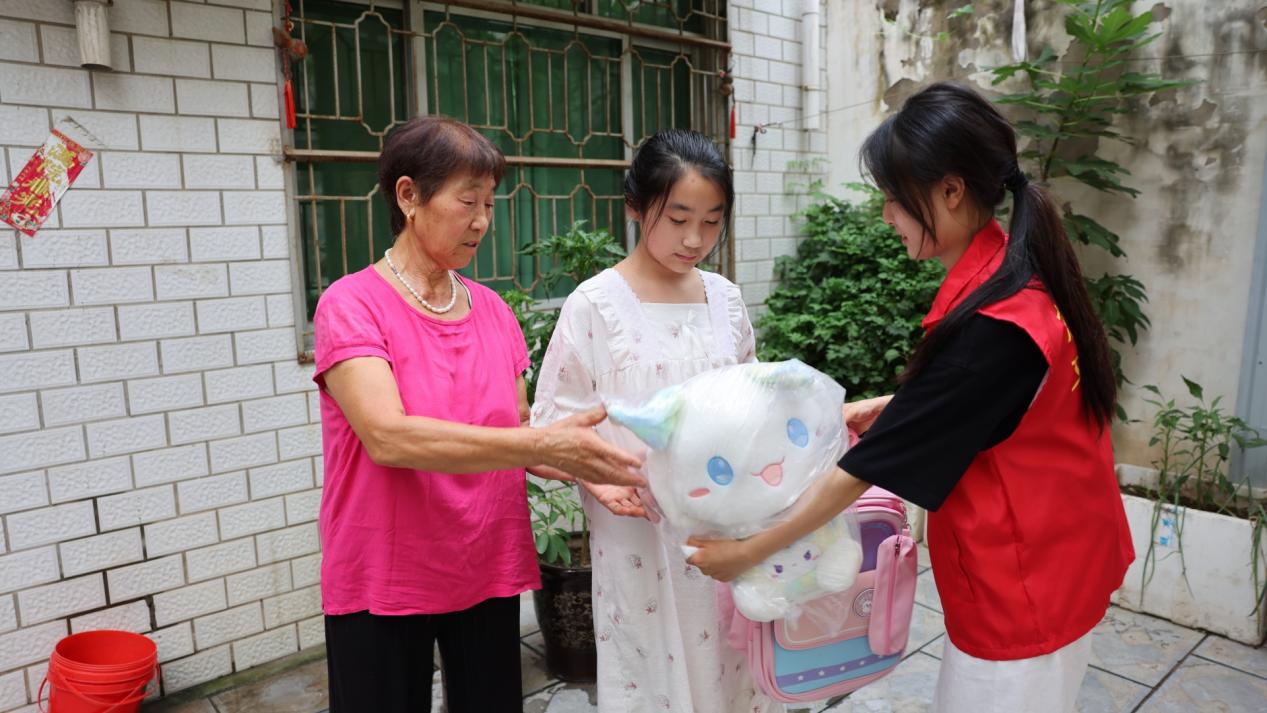 周诗雨把书包文具送到留守儿童手中 孙世杰 摄