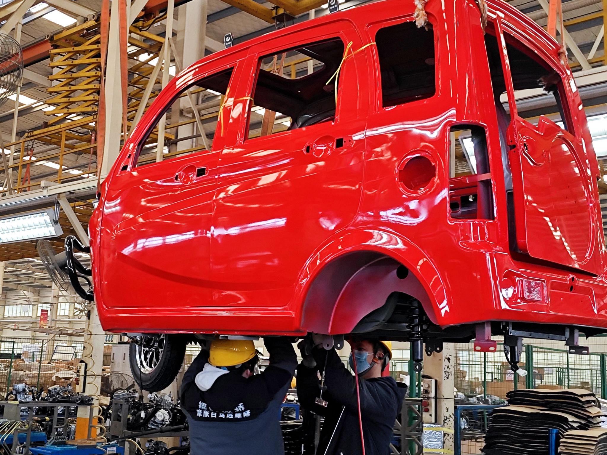 图为洛阳珠峰华鹰三轮摩托车有限公司组装工人在生产线上作业。