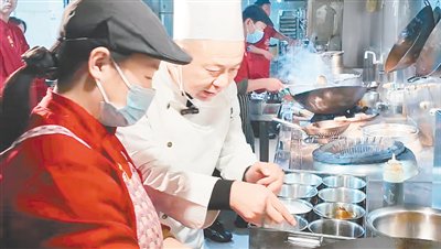 邵开顺（左二）在后厨忙碌