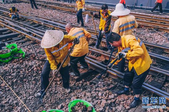 组图:烈日下 他们为铁轨"换枕"