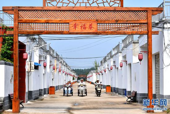 7月25日,河南省夏邑县桑堌乡杨庄村村民在村里幸福巷骑行.