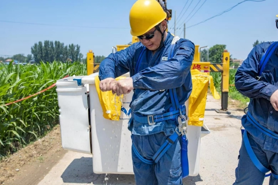 国网河南电力员工冒高温开展带电作业，保障客户正常用电。文琨摄