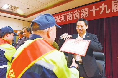 陈天富在向"优秀环卫工人"颁发荣誉证书