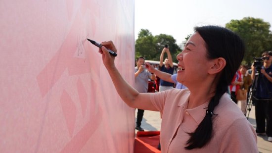 爱心志愿者们在签名墙上签字 孙世杰 摄