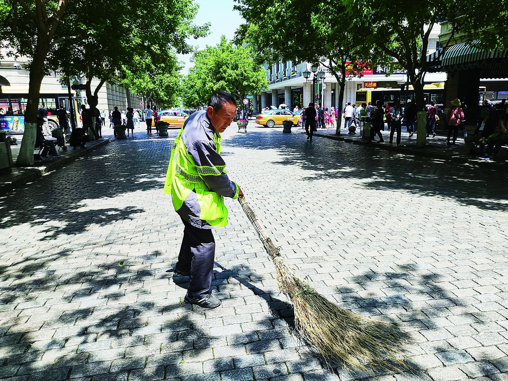 高温下扫街的环卫工人生活报记者张清云摄
