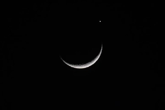 天津星空摄影爱好者刘庆2023年3月24日在天津市区拍摄的金星伴月。