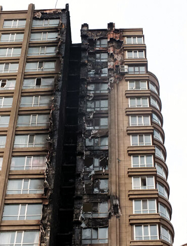 的南侧外墙体已被烧得面目全非,发生火灾的高层楼下方一至三层为商服