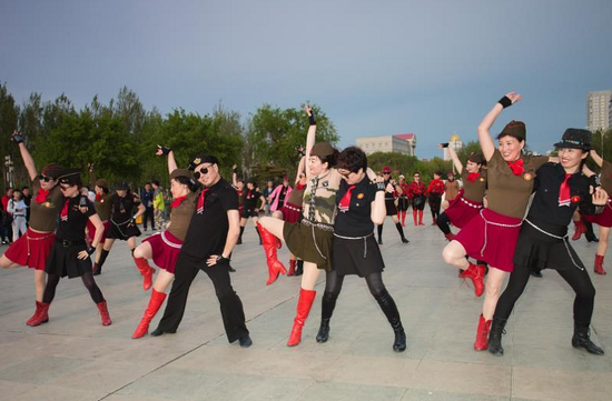 正在购物的人们,从四面八方聚集在商场的中央,50余人组成的水兵舞团队