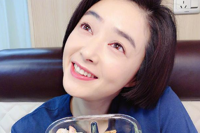 蒋欣手捧美食对镜甜笑 留利落短发皮肤白皙光滑