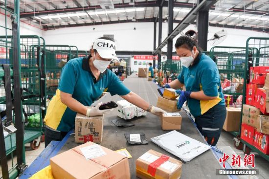 处理中心工作人员对快递包裹进行扫描细分. 杨华峰 摄