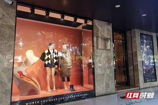 新民路上服装店橱窗玻璃亮如明镜,映树影婆娑.