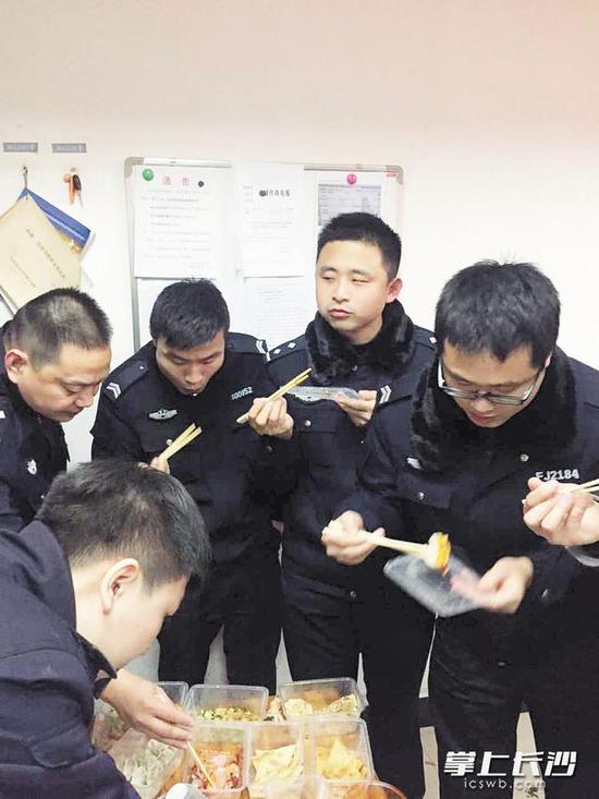 除夕之夜,定王台派出所的值班民警在派出所一起吃盒饭.受访者供图