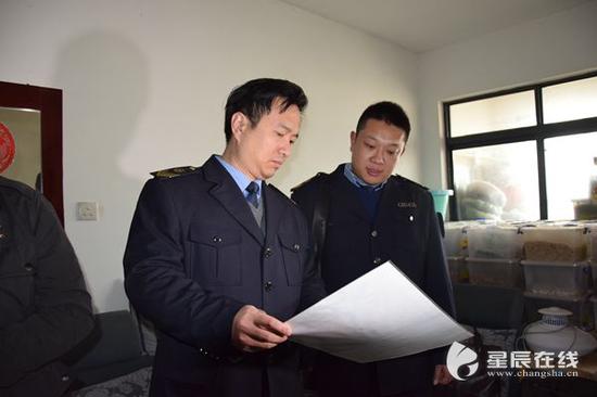 (食药监执法人员正在检查其相关证件.