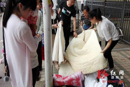 一些居民在"跳蚤市场"询问棉被价钱