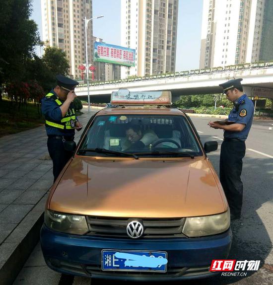交通执法人员检查出租车.
