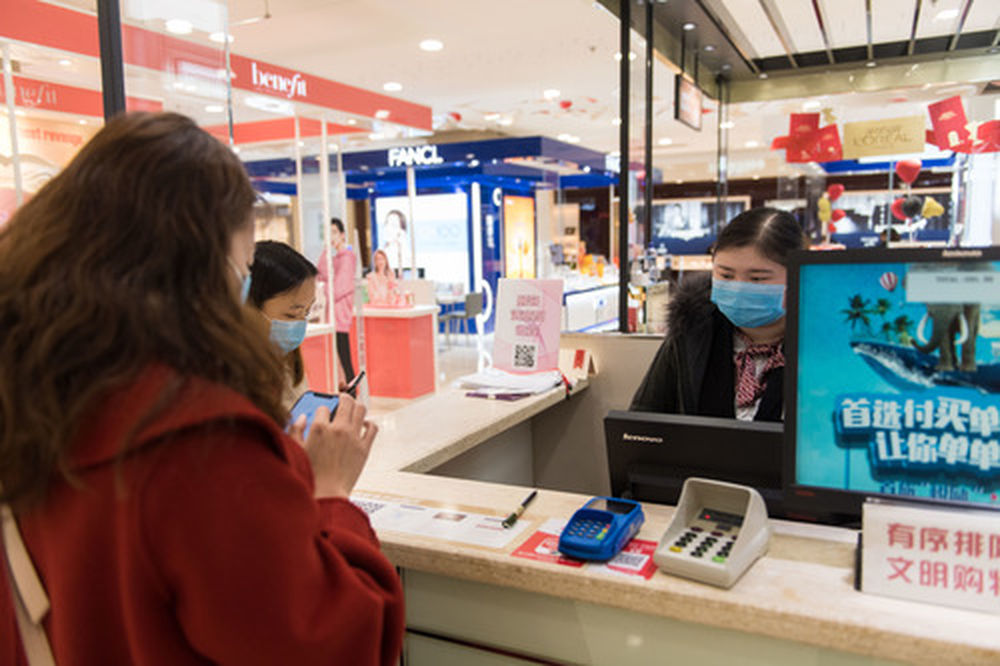 2月10日,在长沙王府井百货商场,消费者在收银台买单.