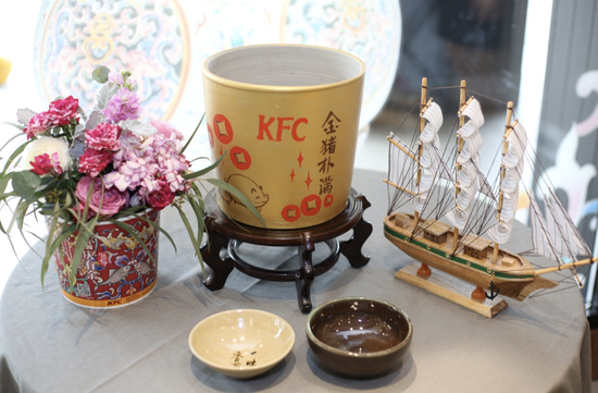 陶瓷烧制技艺省级代表性传承人刘志广(右)将倾情打造的肯德基金猪扑满