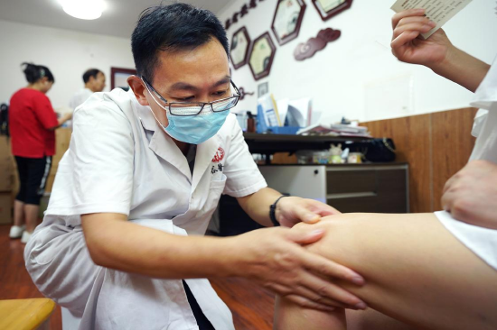 谷式推拿首席养生专家易延光老师为居民按摩穴位
