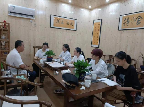 图为团队成员与罗培松的交谈场景。