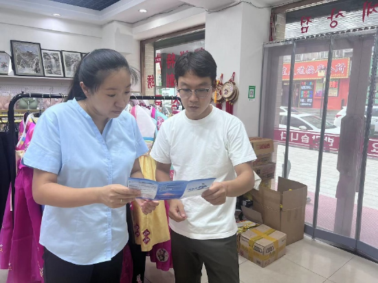 太平人寿丹东中支工作人员在中朝边境“高丽街”向商户宣传金融知识