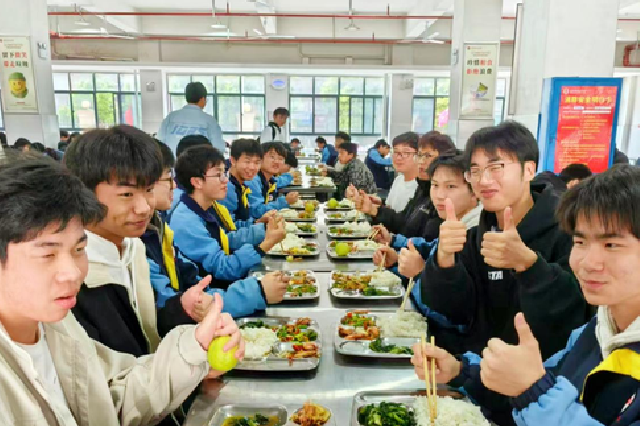 学生们开心地吃着带有“妈妈味道”的校园餐。