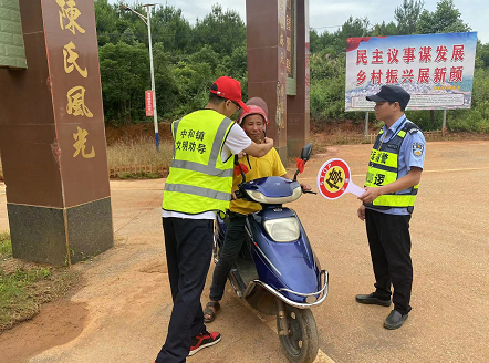 在陈家洞村村口,劝导员正在开展道路交通安全劝导工作