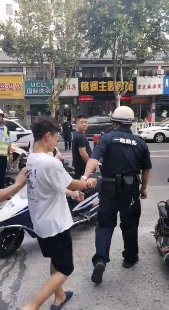 图砍人:酒后持刀砍人的行凶男子被警方带走调查。(网友供图)