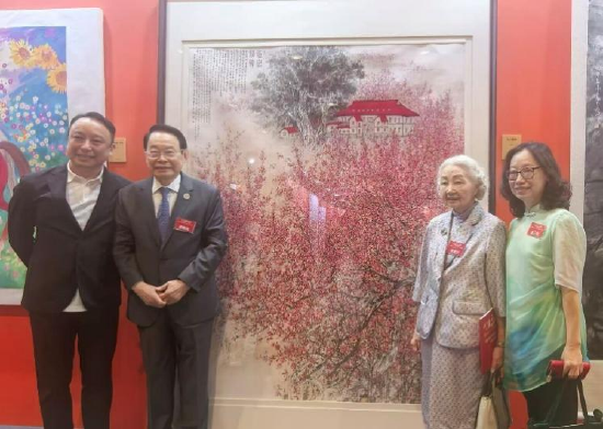 萧晖荣教授与知名人士梁爱诗（右二）在《红岩精神》作品前合影，子女萧扬、萧芬琪陪伴