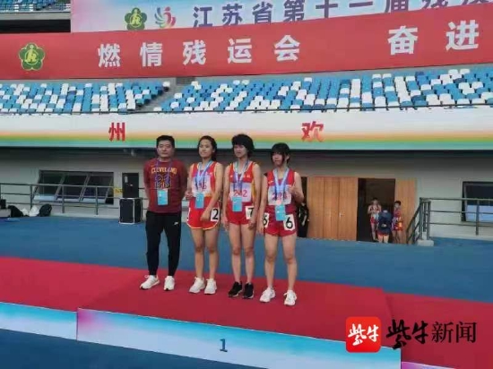 图为听力残疾人王丽(右2)获得田径听力女子青年组800米、1500米和5000米金牌各一枚